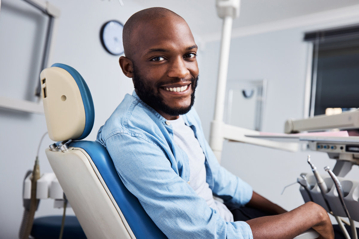 Portrait of a young man having dental work done on his teeth.