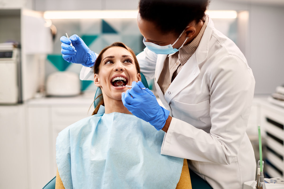 Happy woman having dental examination during appointment at dentist's office.